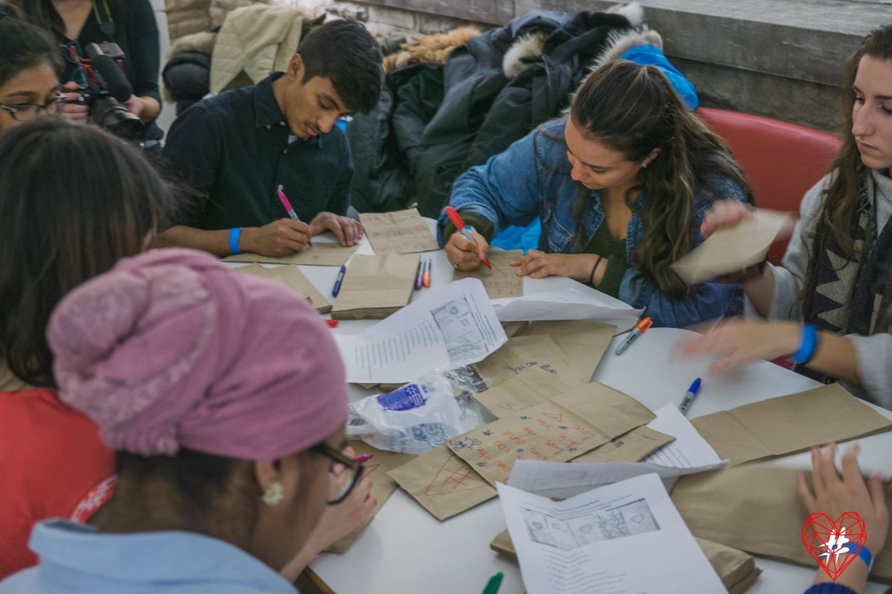 Volunteers writing positive messages on lunch bags